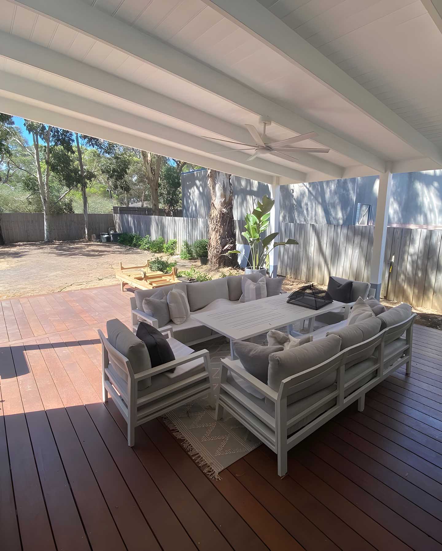 24 Covered timber deck with a white-lined roof and outdoor lounge furniture
